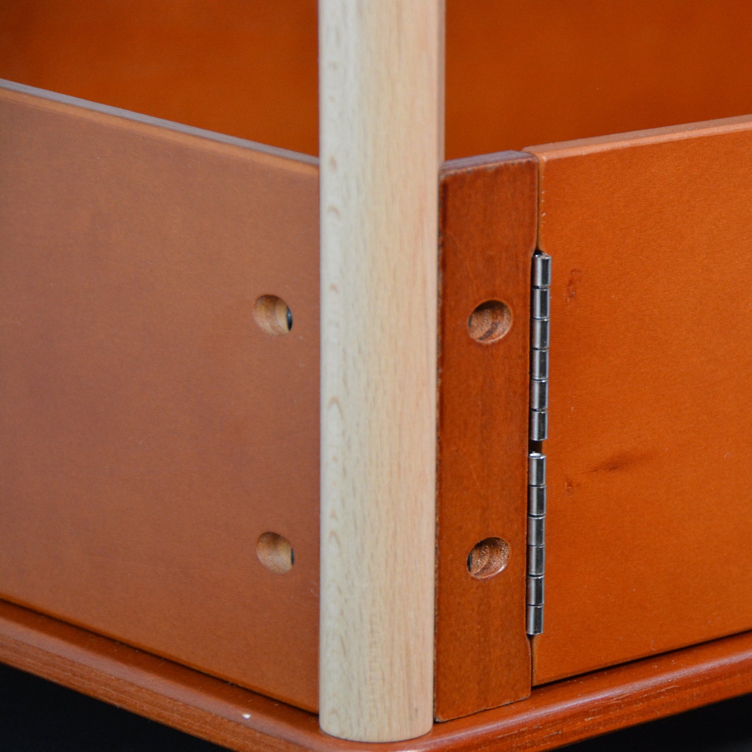 Close-up of a wooden product with a hinge and visible wood grain.