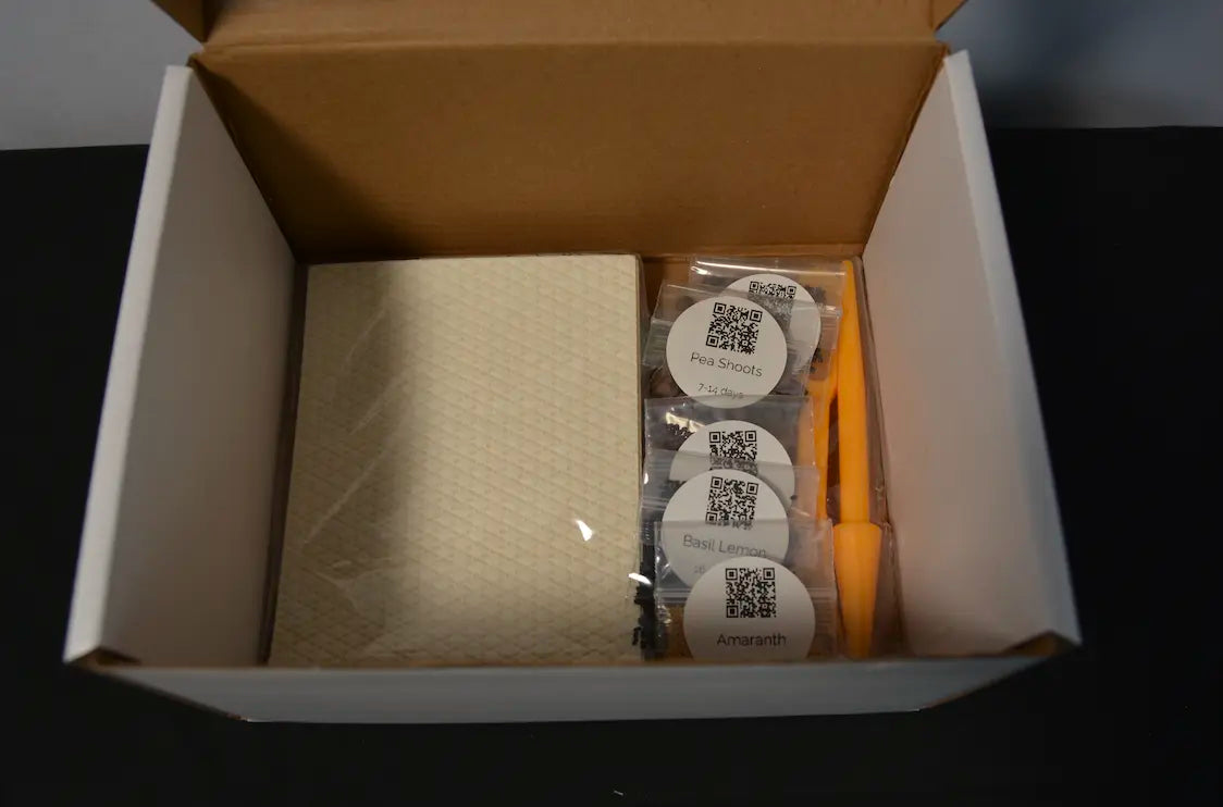 Seed starter tray kit contents including seeds, grow mat, and planting tools for indoor seed starting