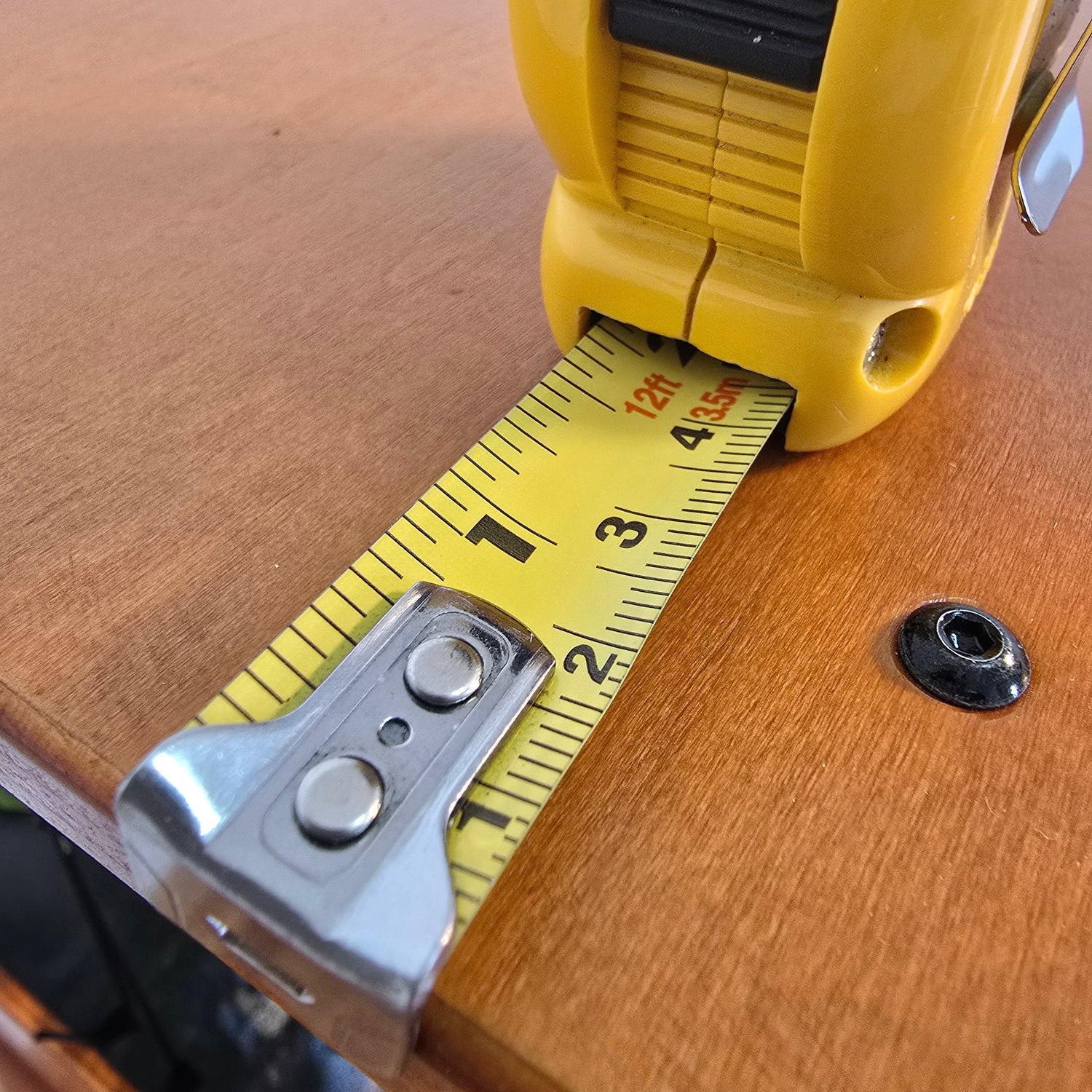 Yellow tape measure extended on a wooden home farm.