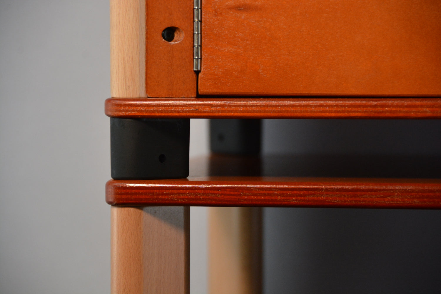 Close-up of a wooden home farm with metal feet and connectors.