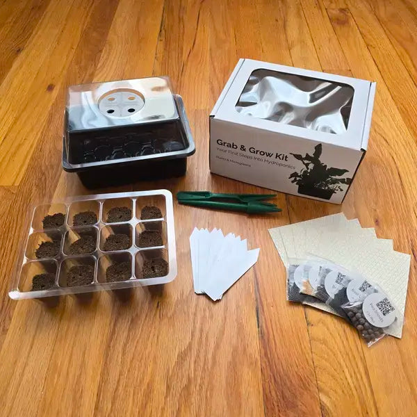 Gardening kit with seed trays, labels, and packaging on a wooden surface