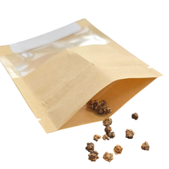Open kraft paper seed packet with small seeds spilled out beside it