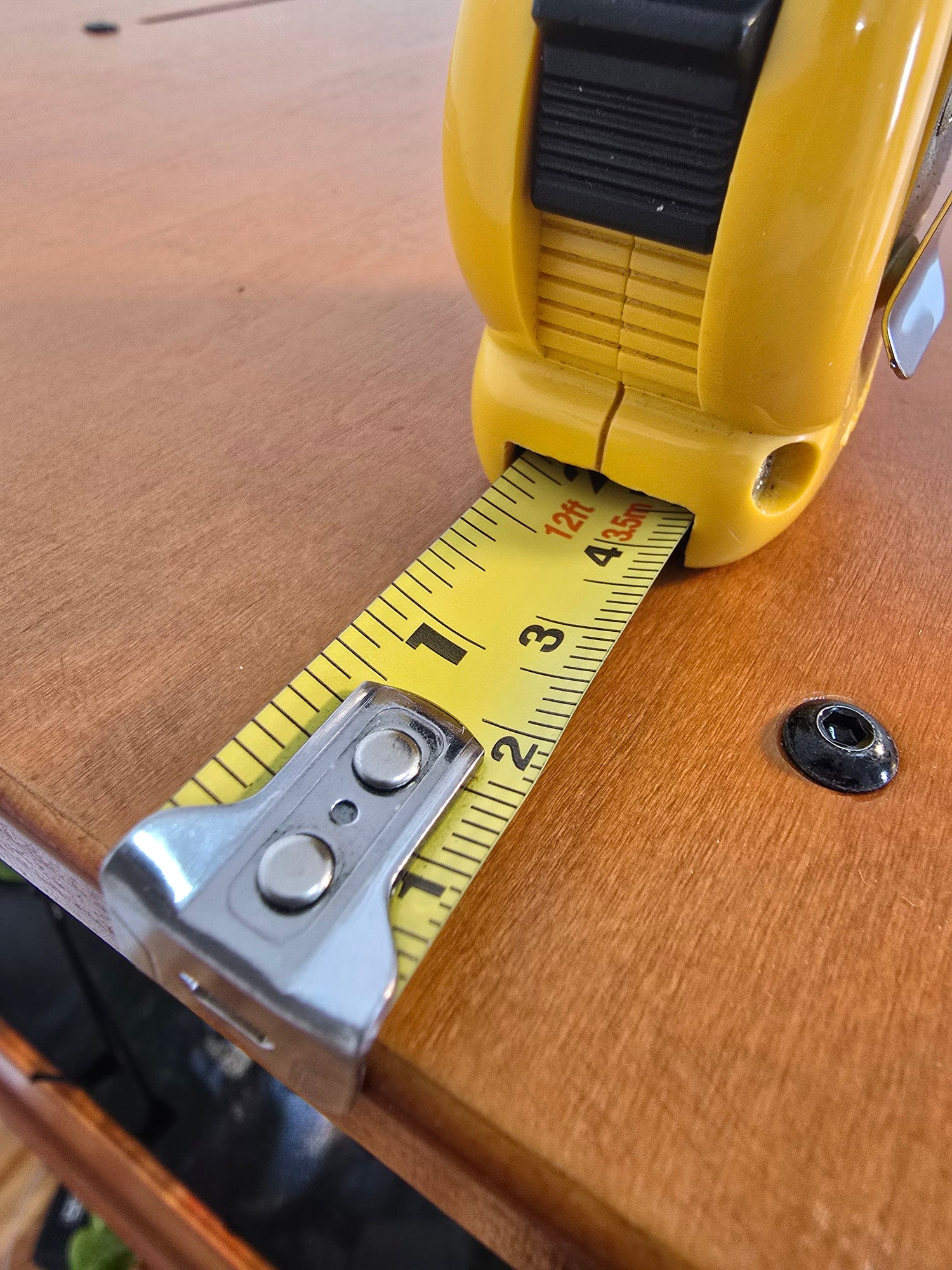 Yellow tape measure extended on a wooden home farm.